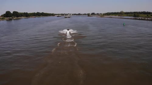Wachen Sie im Sommer hinter einem sich schnell bewegenden Jetski auf dem Fluss auf.