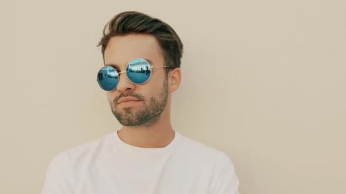 Smiling Man Poses with Round Blue Sunglasses