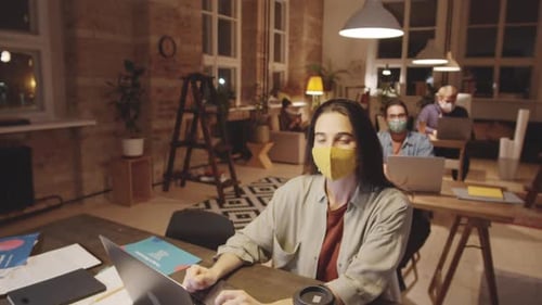 Portrait of Woman in Face Mask Working at Desk in Loft Office
