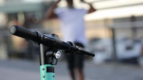 Homme qui marche vers son e-scooter