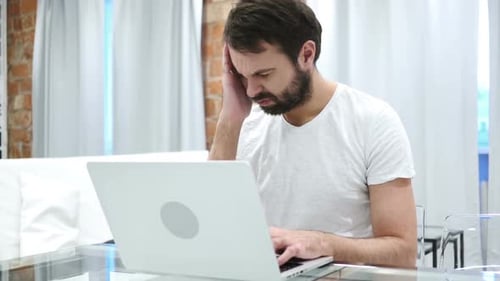 Man Working on Laptop Massaging His Temples