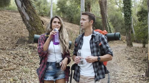 Couple of Backpackers Drinking Fresh Water on Their Way