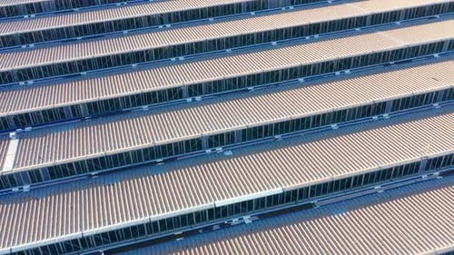 Saw-tooth pattern metal roof of a big factory in a production plant - abstract. Ridges on rooftop.