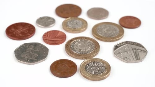 UK Currency pounds coins rotating close up footage against the white background