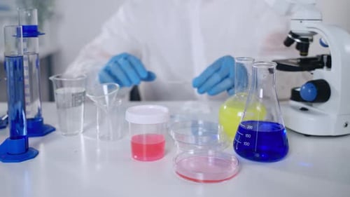 Scientist at Work With Microscope and Lab Equipment