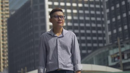 Portrait handsome businessman standing looking around the urban city.