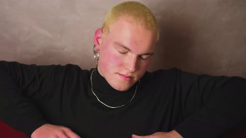 Young Adult Relaxing on Red Sofa