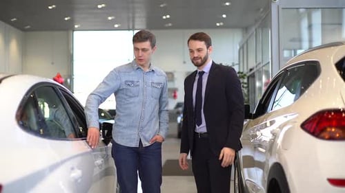 Men Discuss Cars in Showroom