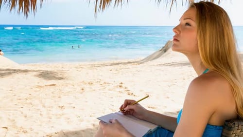 Woman writing on beach