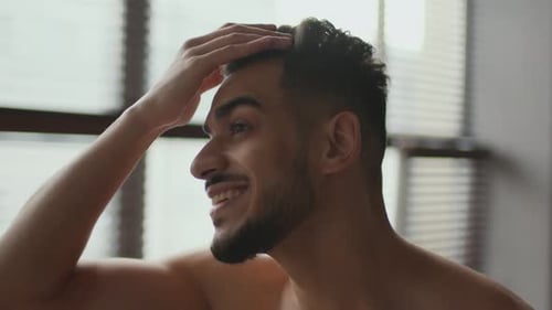 Smiling Man Styling Hair Indoors