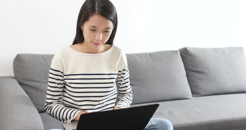 Young Woman Working on Laptop Indoors at Home