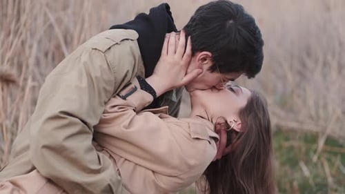 Young Couple Kissing Lovingly in a Natural Field