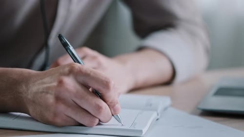 Nahaufnahme unkenntlich Rechtshänder sitzen am Schreibtisch Männlicher Arbeiter halten Stift halten Notizen in der Molkerei