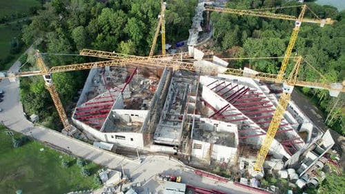 Aerial View Construction of a New Building with High Tower Cranes in Green Area