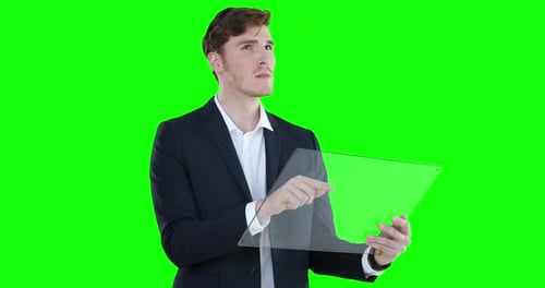 Caucasian man holding a transparent screen on green background
