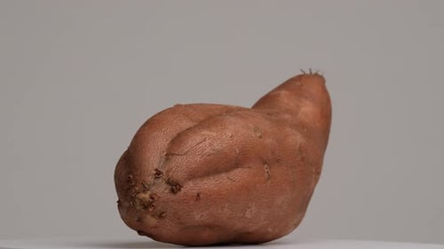 Rotating Single Sweet Potato on White Surface