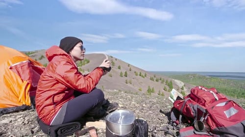 Woman Camping and Taking Pictures on Hilltop