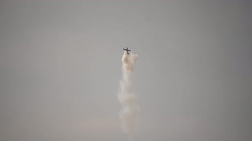 Airplane Performing Aerobatics with Smoke Trails in Sky