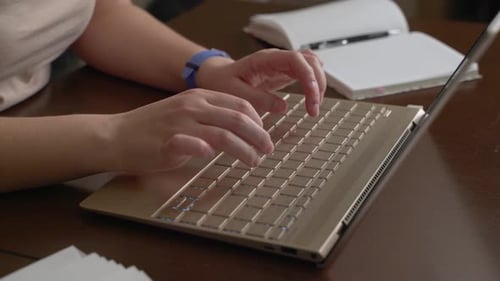 Hands Typing on Laptop Keyboard at Desk