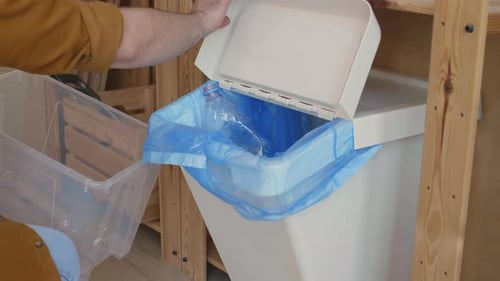 Man Recycling Plastic Bottles Indoors
