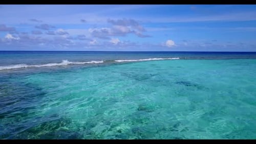Aerial above nature of idyllic coastline beach break by blue lagoon with white sandy background of a