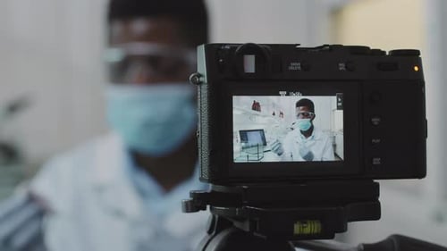 Camera Records Scientist in Lab Conducting Experiment