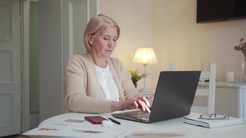 An Old Woman Works at a Computer