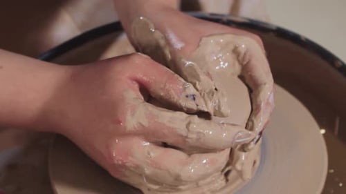 Hands Shaping Clay on a Pottery Wheel