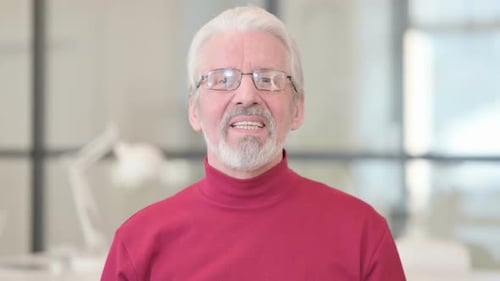 Smiling Senior Man Waving and Talking to Camera