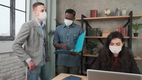 Modern International Office. Workers and Managers in Medical Masks Working at Laptop and Discuss