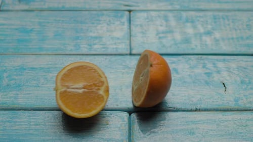 Halved Orange Displayed on Light Blue Wood