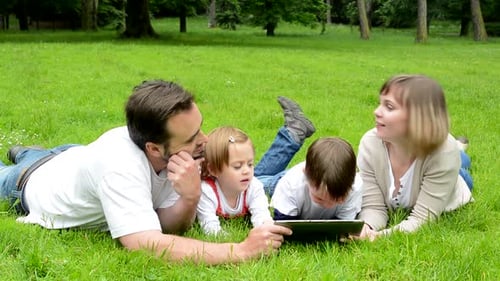 Family, Middle Aged Couple in Love, Boy and Girl, Lying in Grass and Work on Tablet