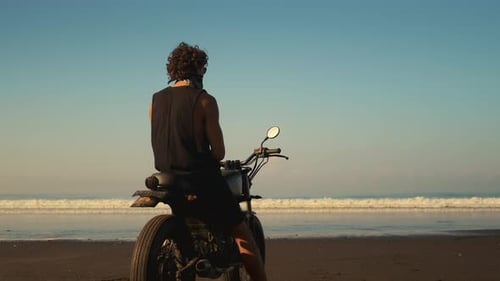 Bold Thoughtful Biker Staring at the Ocean