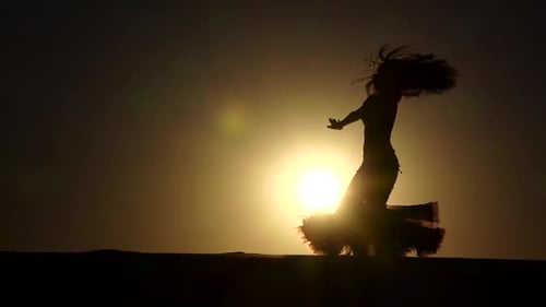 Silhouette of Woman Dancing on Desert Sand Dune