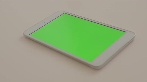Silbernes PC-Tablet auf weißem reflektierendem Hintergrund mit grünem Bildschirm Chroma 4K 2160p UltraHD Fuß