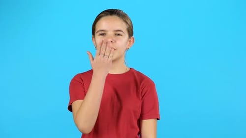 Teen Girl Blowing Kiss on Bright Blue Background