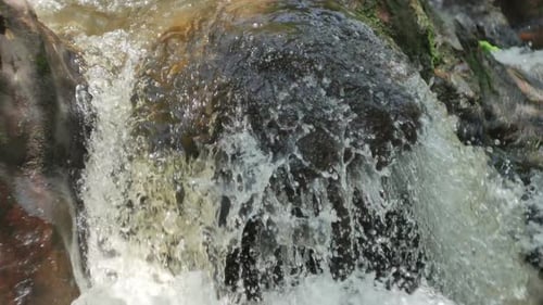 Water Cascading Over Rocks in Close Up