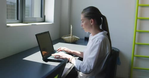 Young Business Woman Sitting in Startup Office Using Laptop Computer