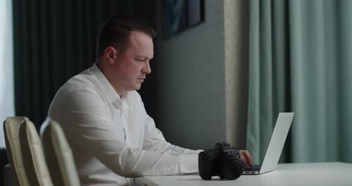 Adult Man Working on Laptop with Camera
