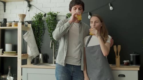 Young Couple Enjoying Juice in Modern Kitchen