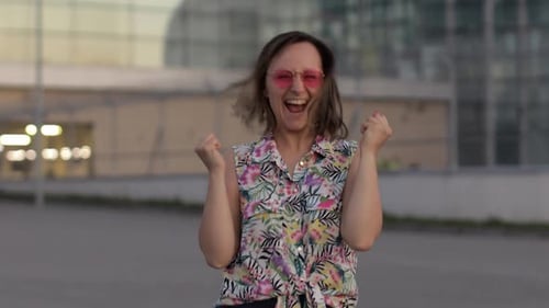 Woman Celebrating with Raised Arms Outdoors