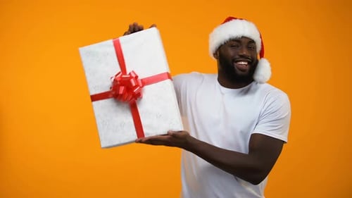 Cheerful Man Holds Christmas Gift