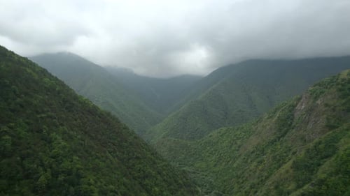 Wunderschönes Bergtal mit viel Grün und bewölktem Himmel