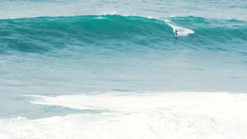 Surfer Riding Ocean Wave on Bright Day