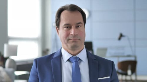 Man in Suit Smiles and Nods Approval