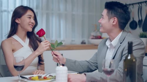 Romantic Couple Sharing a Rose on Dinner Date
