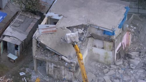 Excavator Demolishing Building in an Urban Setting