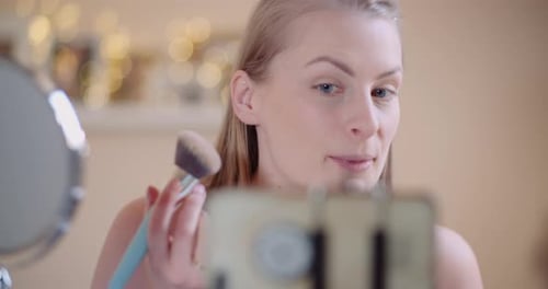 Maquilladora Youtuber femenina que ejecuta un curso de maquillaje en línea