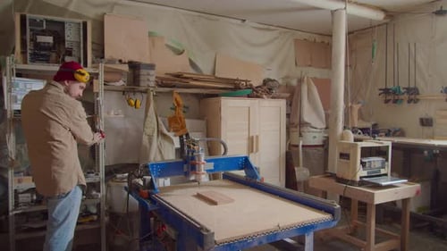 Man Programming Woodworking Machine in Shop