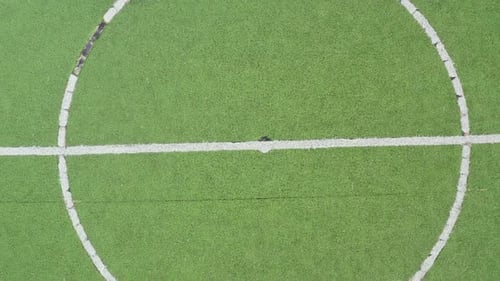 Midpoint of an artificial grass football field zooming out to reveal the field